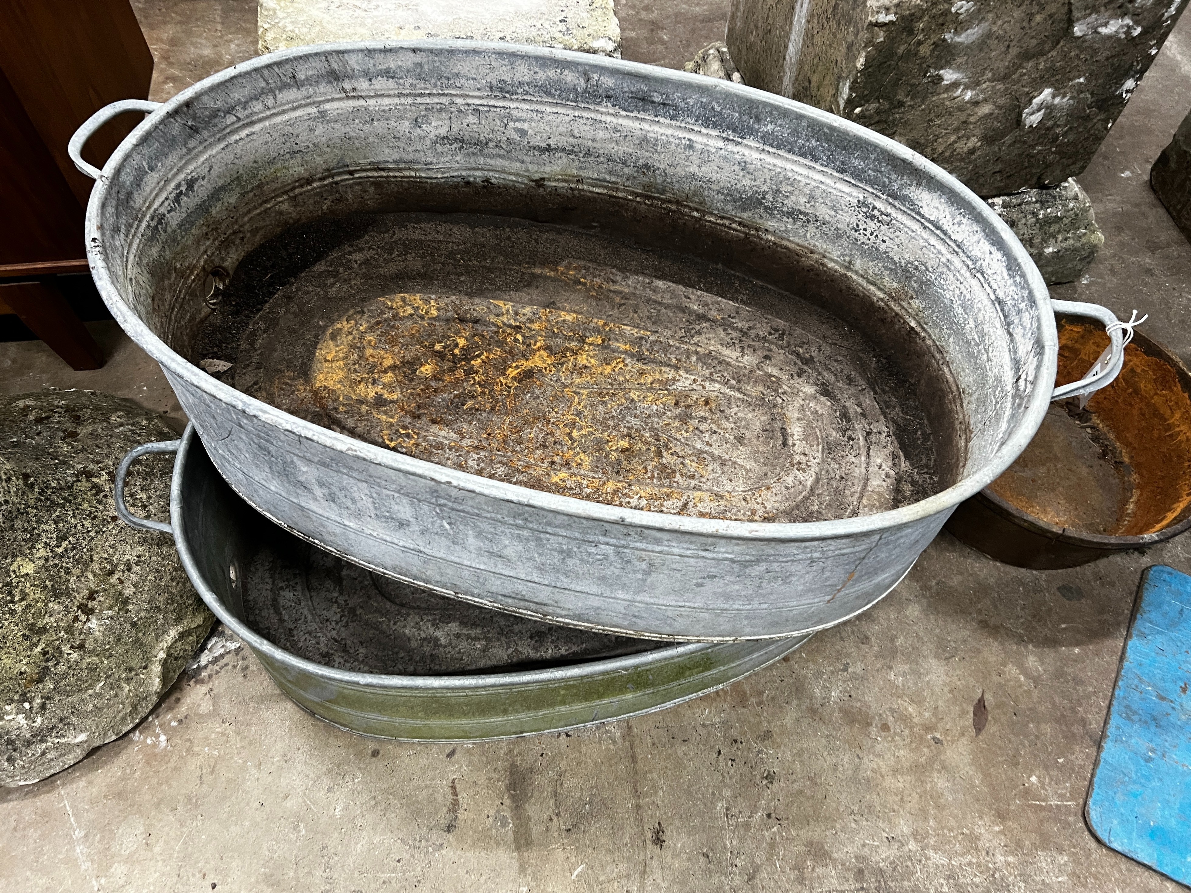 A pair of oval vintage galvanised zinc water troughs, length 104cm, depth 58cm, height 28cm together with a smaller circular cast iron planter